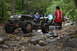 1984 Ford Bronco II - Several modified Jeeps navigate a challenging, rocky trail through a wooded area.