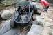 1984 Ford Bronco II - A custom off-road buggy navigates a challenging rocky terrain, with a person watching from the side.