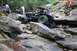1984 Ford Bronco II - A custom off-road vehicle tackles a challenging rocky terrain with spectators observing the side.