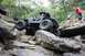 1984 Ford Bronco II - An off-road vehicle navigates a challenging rocky terrain with spectators observing the action.