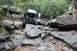 1984 Ford Bronco II - A custom off-road vehicle navigates a challenging rocky terrain with spectators observing the action.
