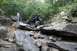 1984 Ford Bronco II - Custom off-road buggy tackles a challenging rocky obstacle course in a wooded area.