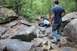 1984 Ford Bronco II - Off-road vehicles tackle a challenging rocky path in a wooded area.