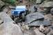 1984 Ford Bronco II - Jeep Wrangler tackling a difficult rocky obstacle on an off-road trail.