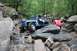 1984 Ford Bronco II - A blue Jeep is carefully driven over large rocks on a wooded trail.