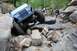 1984 Ford Bronco II - A blue Jeep navigates a challenging rocky terrain with spectators observing the action.