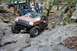 1984 Ford Bronco II - Modified Jeep Grand Cherokee tackling a difficult off-road course with other vehicles present.