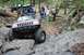 1984 Ford Bronco II - This modified Jeep navigates a rocky off-road course, with other vehicles and spectators present.