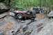 1984 Ford Bronco II - Multiple off-road vehicles navigate a rocky trail through a wooded area.