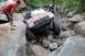 1984 Ford Bronco II - A Jeep navigates a challenging rocky terrain with onlookers present.