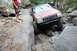 1984 Ford Bronco II - A Jeep Cherokee XJ tackles a challenging rocky off-road course, demonstrating its capability on uneven terrain.