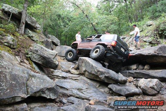Brown Jeep Cherokee XJ navigating rocky terrain