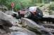 1984 Ford Bronco II - A Jeep navigates a challenging rocky terrain with a person watching from a boulder.