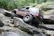 1984 Ford Bronco II - A Jeep Grand Cherokee navigates a challenging rocky terrain, demonstrating its off-road capabilities.
