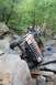 1984 Ford Bronco II - A Jeep Cherokee XJ navigates a difficult rocky trail, with one wheel lifted high off the ground.