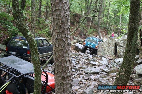 Blue SUV and black SUV on rocky off-road trail