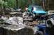 1984 Ford Bronco II - Multiple off-road vehicles tackle a challenging rocky trail in a wooded area.
