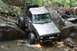 1984 Ford Bronco II - This modified SUV is attempting to cross a water obstacle on a rocky trail.