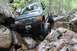 1984 Ford Bronco II - Modified SUV tackling a challenging off-road course with large boulders.