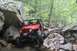 1984 Ford Bronco II - Off-road Jeep Wrangler tackling a challenging rocky terrain in a wooded area.