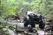 1984 Ford Bronco II - Two off-road vehicles, a 1984 Ford Bronco II and a red Jeep, tackle a challenging rocky path.