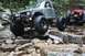 1984 Ford Bronco II - Two off-road vehicles tackle a challenging rocky path, with one vehicle prominently featured.