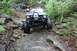 1984 Ford Bronco II - Modified 1984 Ford Bronco II tackles a challenging rocky off-road course, with another vehicle visible in the background.
