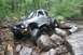 1984 Ford Bronco II - This modified SUV navigates a challenging rocky terrain with its tires angled for maximum traction.