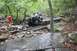 1984 Ford Bronco II - Bronco II tackling a challenging rocky obstacle course in a forest setting.