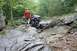 1984 Ford Bronco II - Off-road buggy carefully maneuvers through a rocky, wet terrain with a person observing the path.