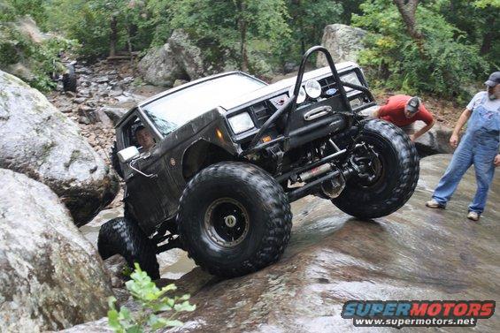 1984 Ford Bronco II modified for off-roading, climbing over rocks in a stream