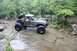 1984 Ford Bronco II - This heavily modified truck, possibly a Ford Ranger or Bronco II, tackles a challenging off-road course with large tires and a lifted suspe…