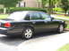 2003 Ford Crown Victoria - Side view of a black 2003 Ford Crown Victoria parked on a driveway.