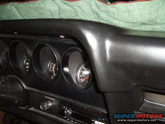 Black dashboard interior with four circular gauges, a radio, and a "SUPER-WASH" label