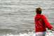 1990 Chevrolet Suburban - A person wearing a red hooded sweatshirt stands by the water, with text printed on the back of the garment.