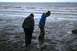 1990 Chevrolet Suburban - Two individuals examine the tidal flats at Captain Cook State Park on a cloudy day.
