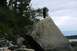 1990 Chevrolet Suburban - Two individuals stand atop large boulders near a body of water under a cloudy sky.