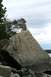 1990 Chevrolet Suburban - A person sits on a large rock formation overlooking a body of water under a cloudy sky.