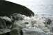 1990 Chevrolet Suburban - Water crashes against the rocky shore, creating a dynamic spray.