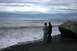 1990 Chevrolet Suburban - A couple contemplates the vast ocean from a rocky shore on an overcast day.