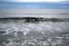 1990 Chevrolet Suburban - The ocean churns with white foam under a gray sky.