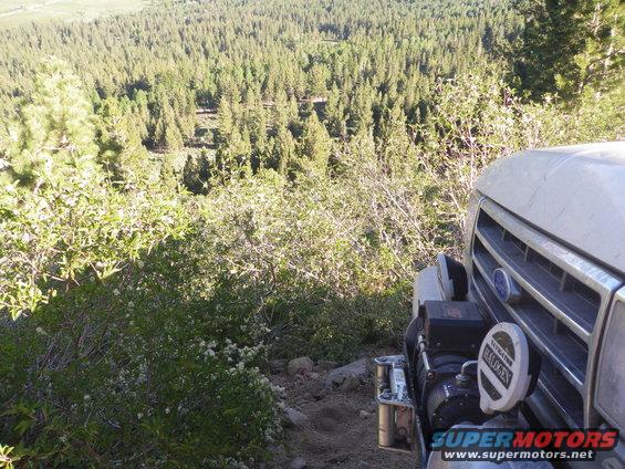 Silver 1991 Ford Bronco front with winch and halogen lights on a wooded trail
