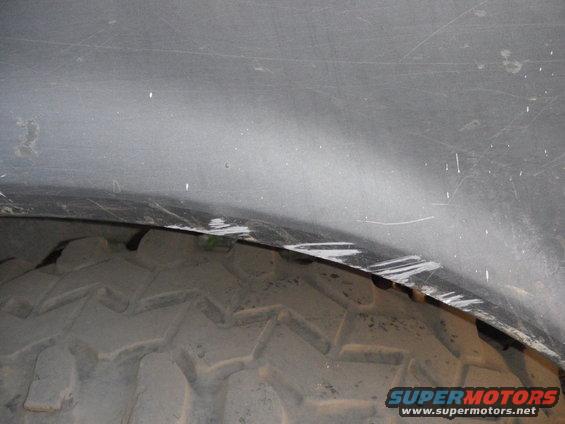 Close-up of a tire tread and the inside of a vehicle's wheel well
