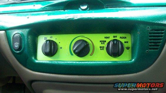 Green dashboard climate controls with three knobs and vent settings