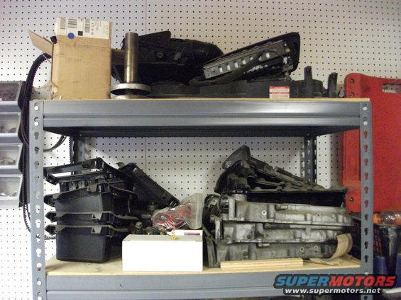 Shelves with various car parts, including an engine block and plastic components