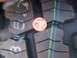 1989 Ford Bronco - Close-up of tire tread with a penny for scale, showing the tread pattern and colored wear indicators.