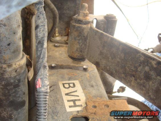 Close-up of rusty vehicle suspension parts with a label reading BVH