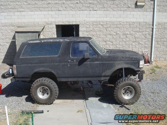 Black 1992 Ford Bronco side view, lifted with large tires