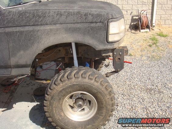 Front fender and tire of a lifted Ford truck, possibly F-150 or Bronco, with aftermarket bumper bracket