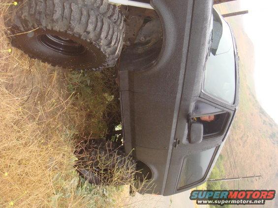Off-road SUV with large tires parked on a grassy slope